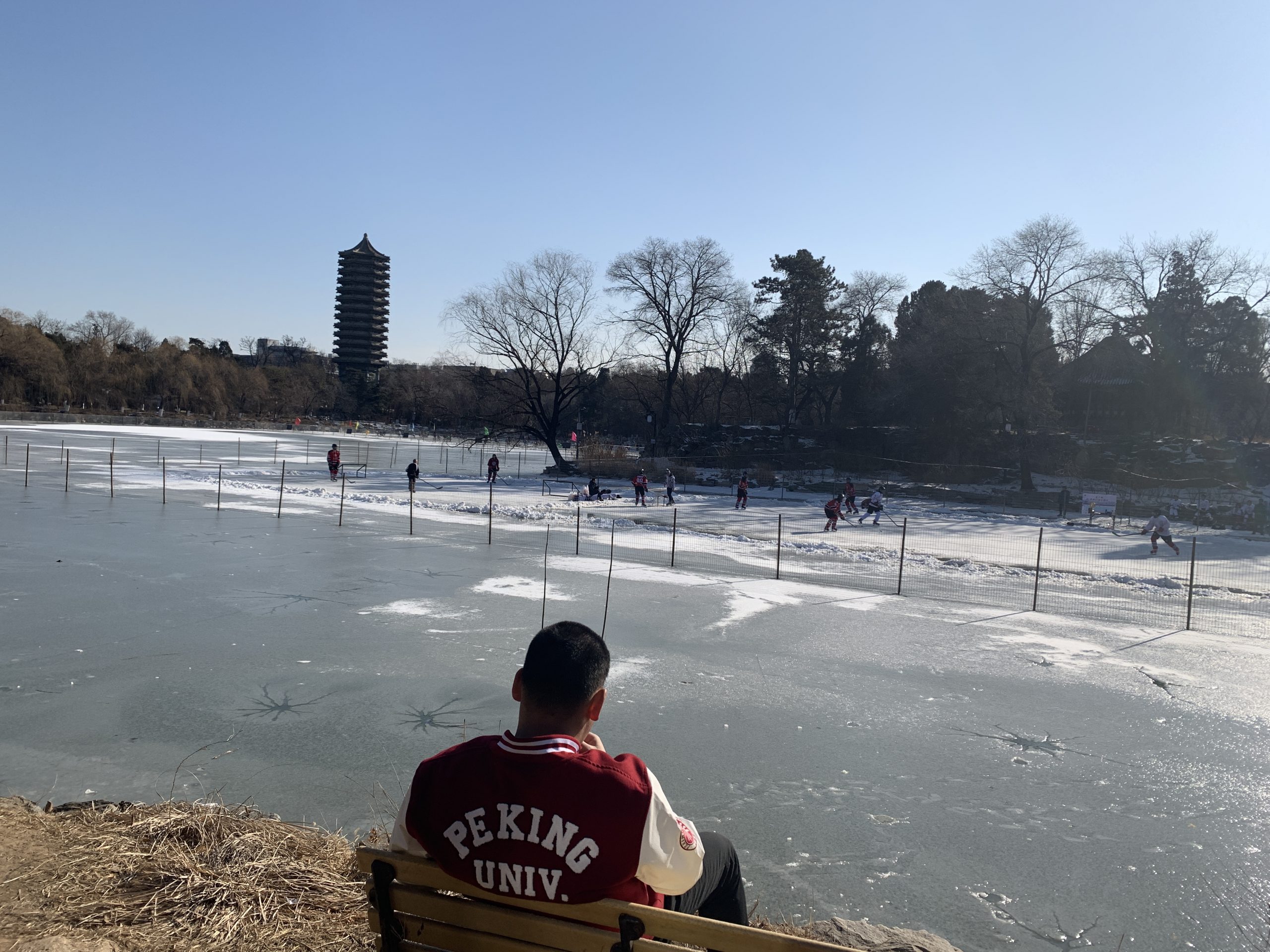 Weiming Lake in winter, frozen over with hockey players in the middle of a match