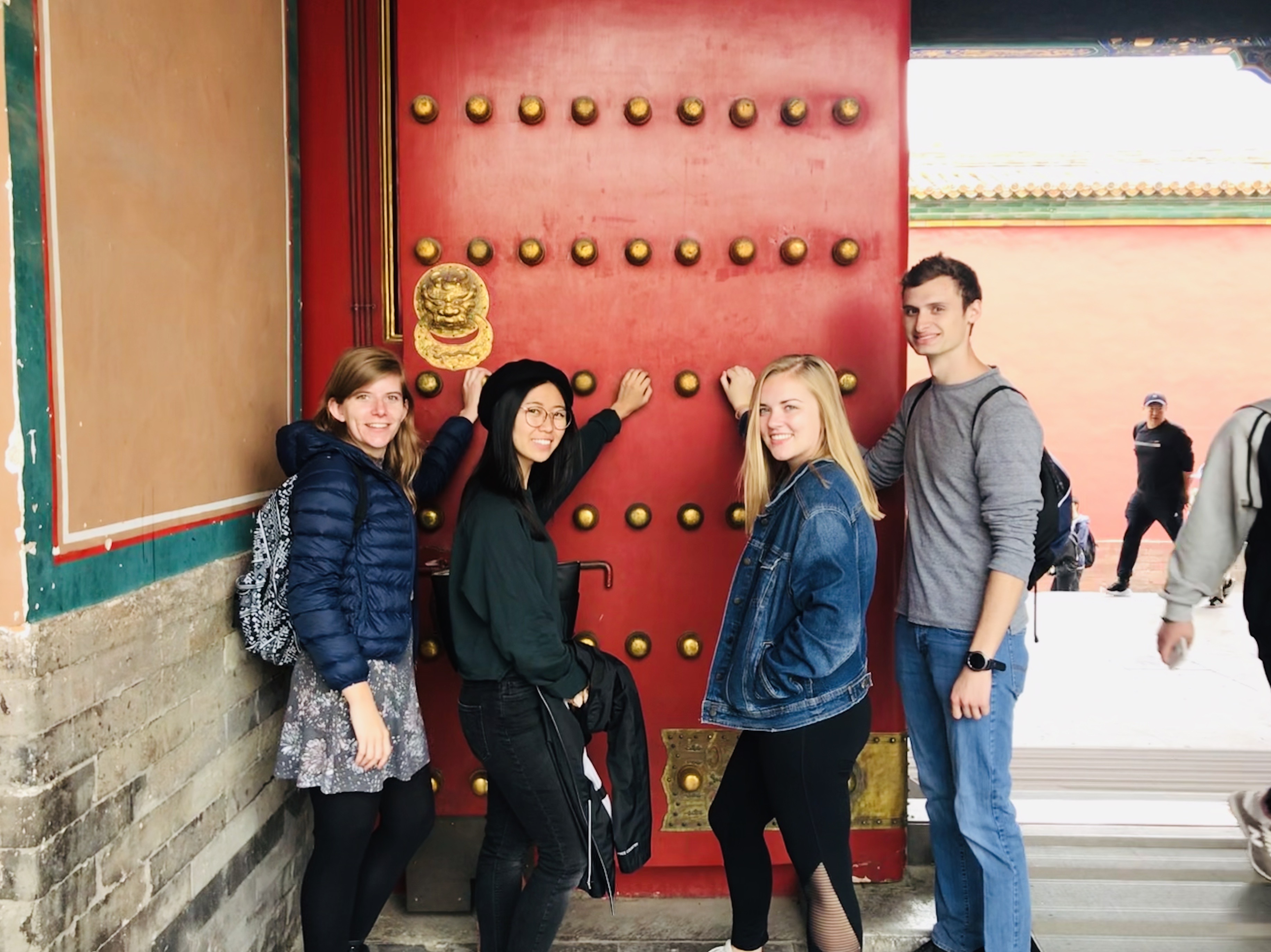 Friends in the Forbidden City touching the knobs for good fortune