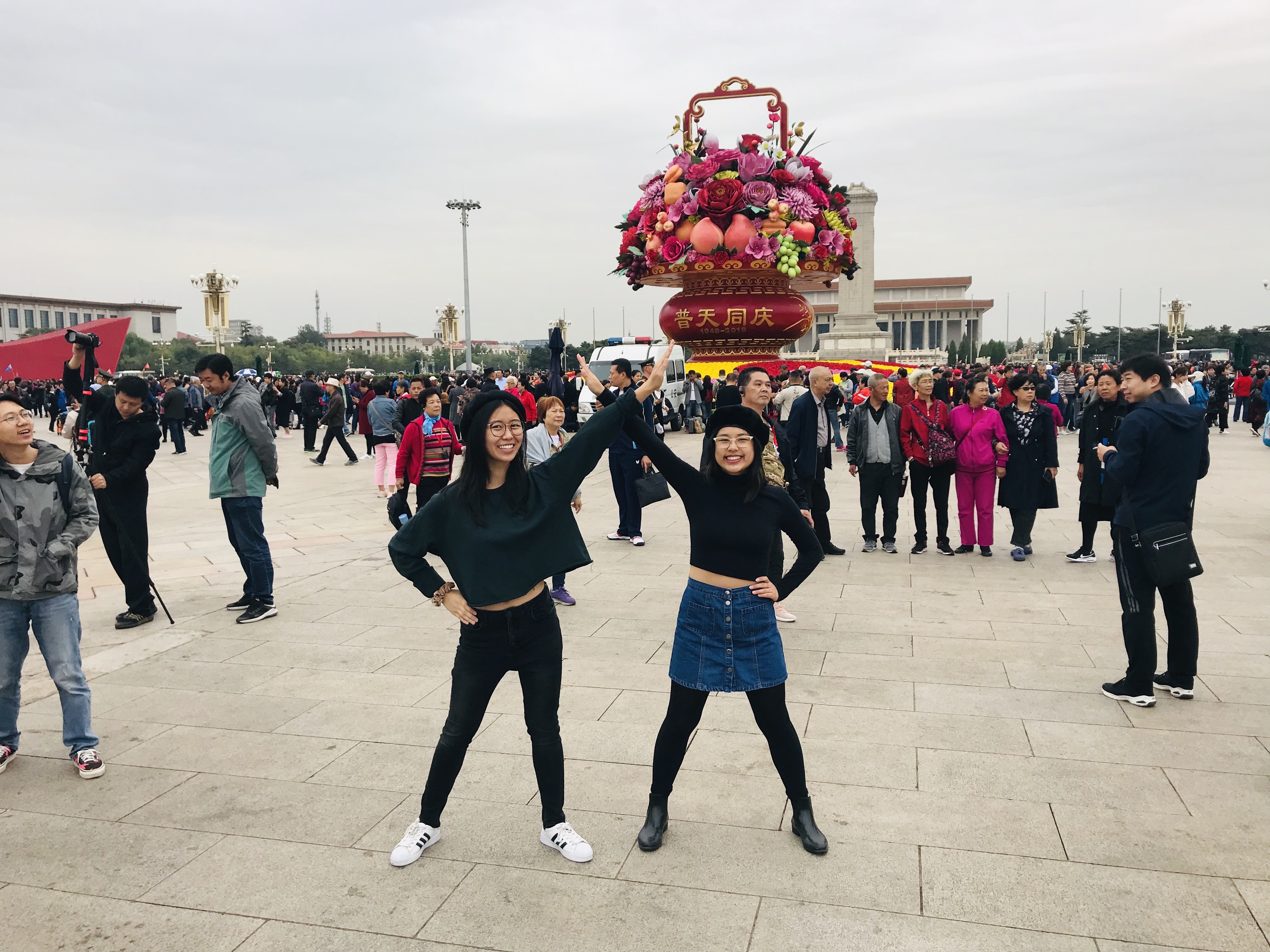 Sarah and I in Tiananmen posing with a large display of flowers behind us.