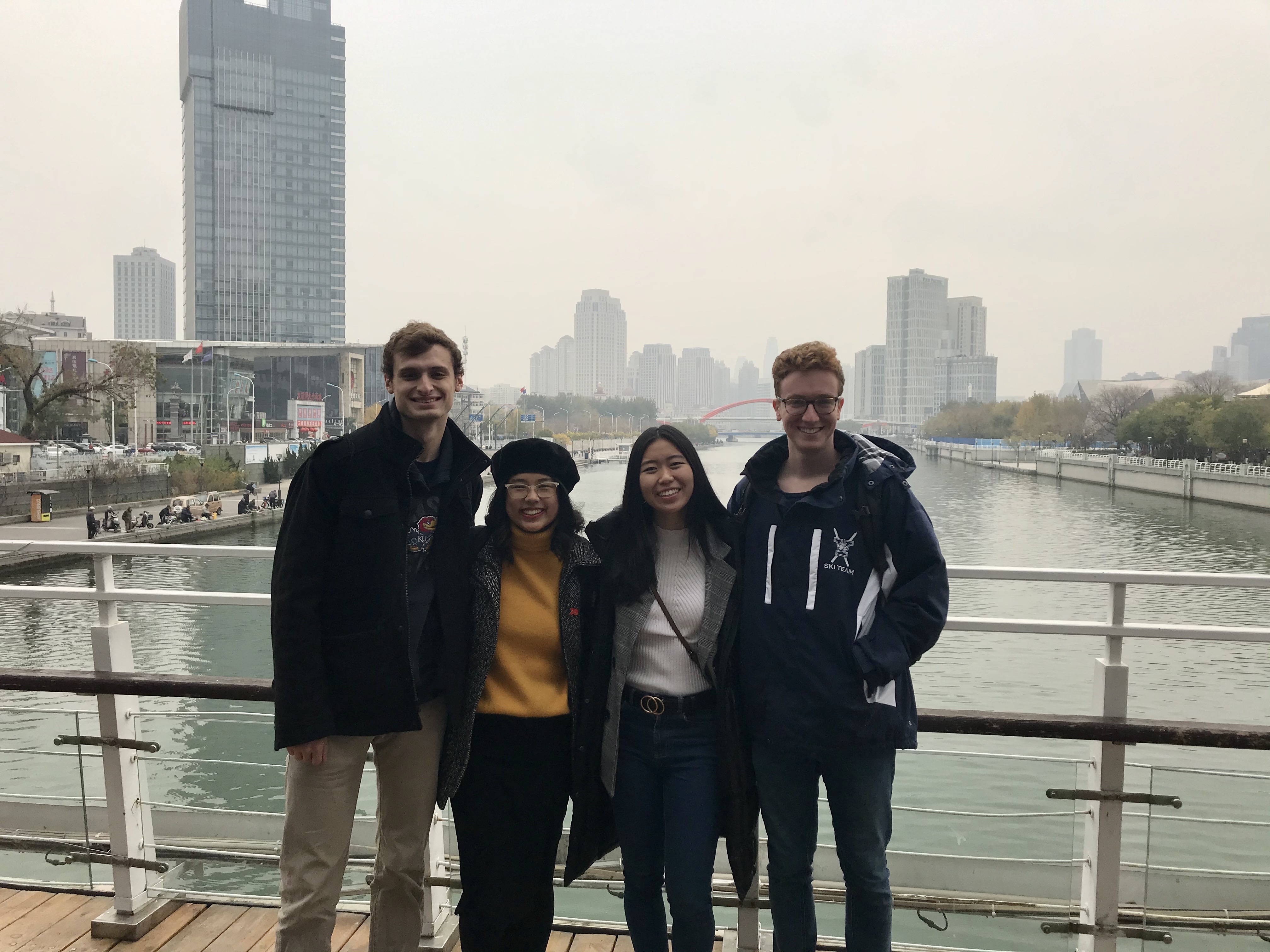 Group photo on bridge overlooking river and skyline in Tianjin