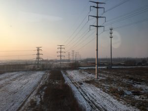 The view from the train across the frozen fields and electric poles.