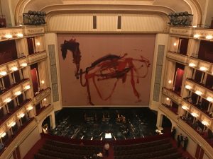 Front view of the stage in the Vienna State Opera House displaying art.