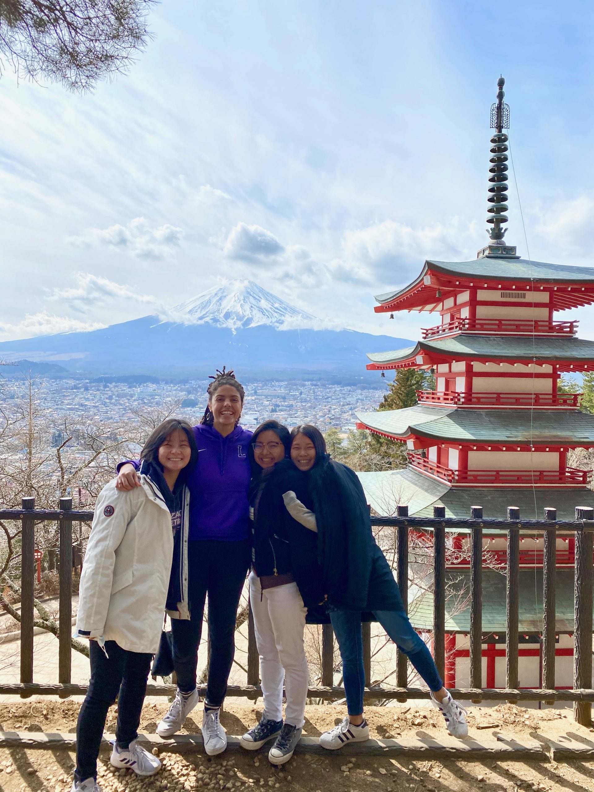 Me, Isis, Marina, and Emi posing in front of Mt. Fuji and a red/green temple