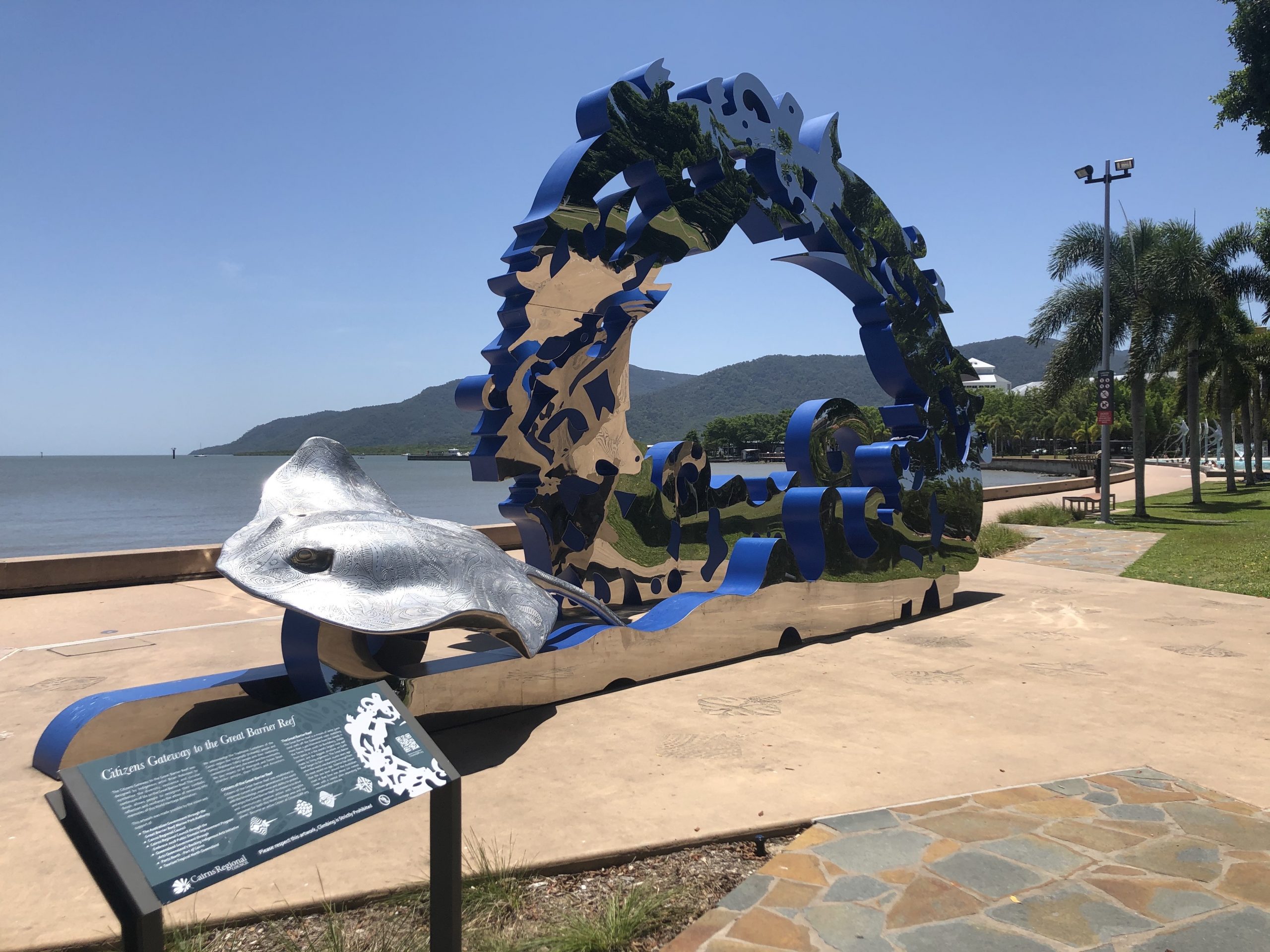 The Cairns city esplanade: a large metal sculpture in front of the ocean, which serves as the gateway to the great barrier reef.