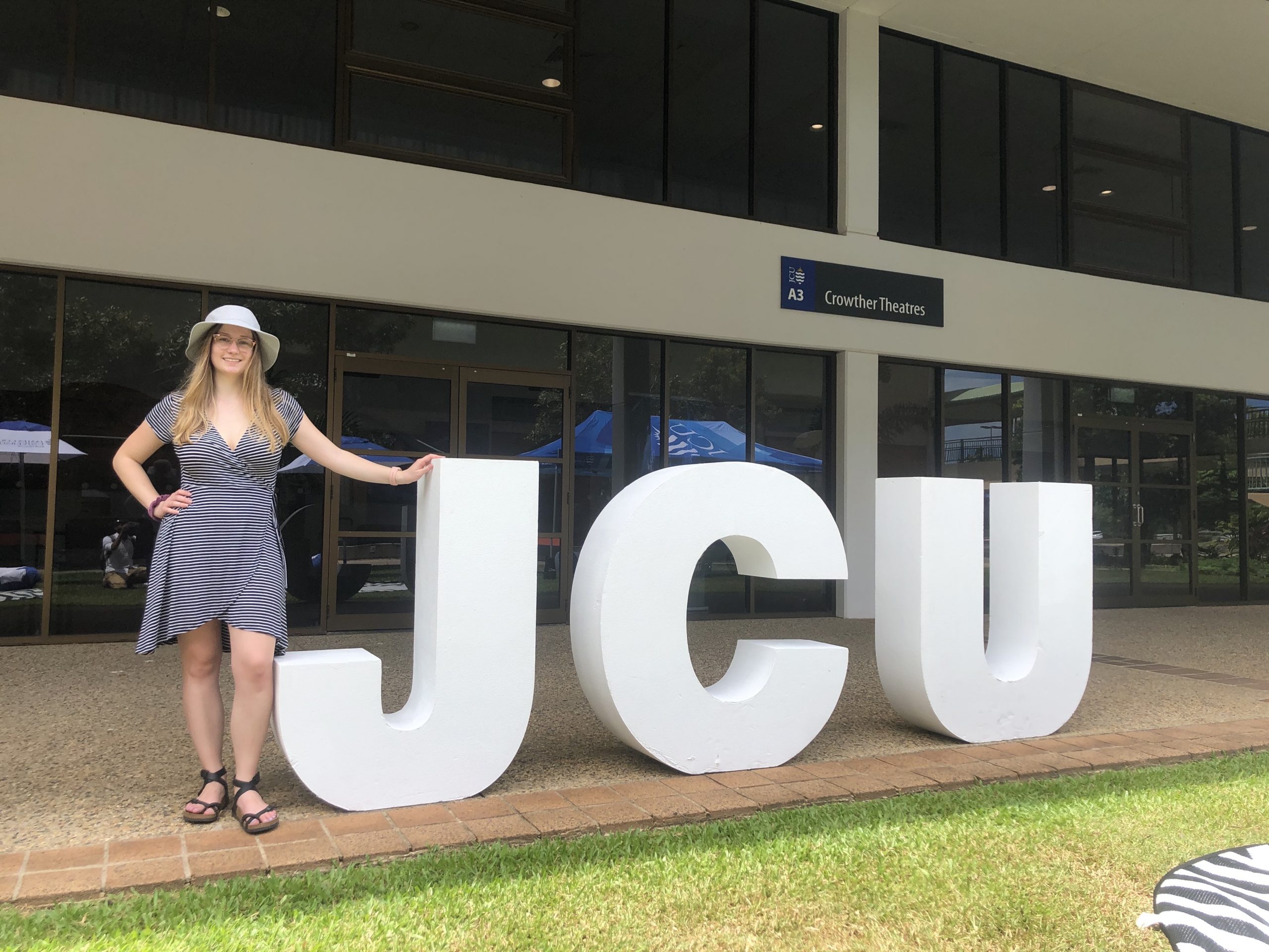 Christina standing next to the letters "j" "c" and "u"