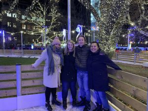 4 of our student group posing on ice skates on a ice ring