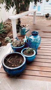 A collection of beautiful blue ceramic pots on a deck