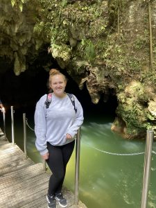 Emmaline standing outside of the cave entrance 