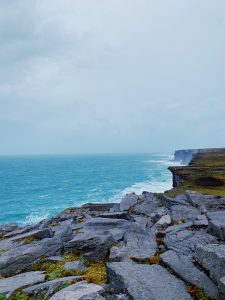 Inis Mór - looking over rocks out to blue ocean, cloudy skies