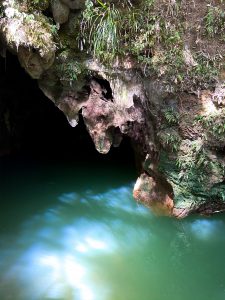 Milky blue water at the entrance of a cave