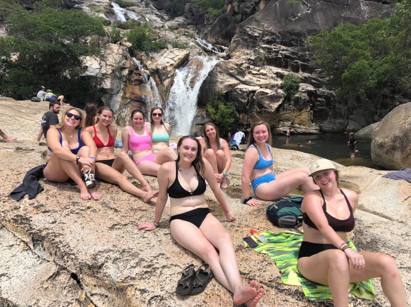 Christina and a group of friends sunbathing by the waterfall