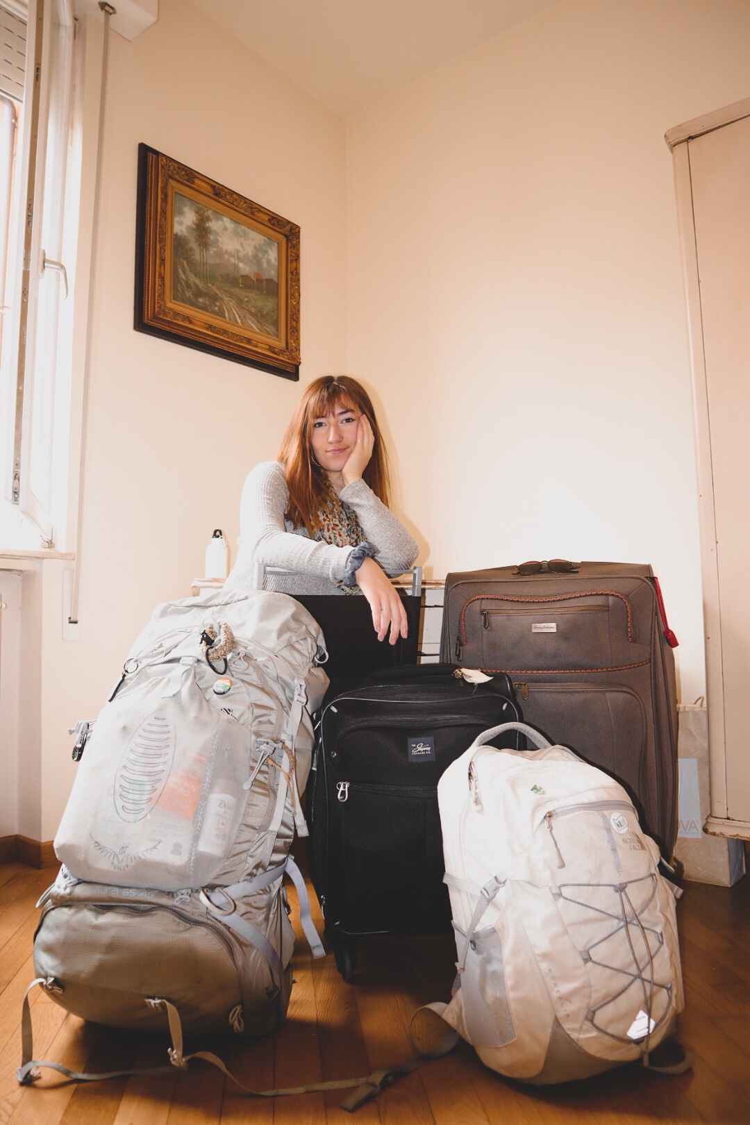 Girl in her room with all her luggage.