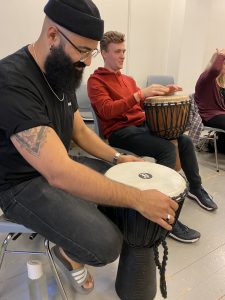 Two students holding drums in a music classroom