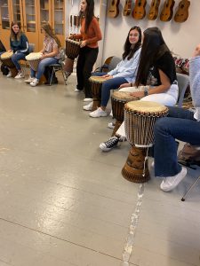 A line of students holding drums in a music classroom