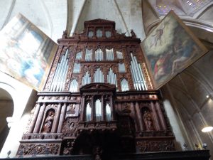 The organ of the Tarragona is brown and accompanied by two paintings on the sides.