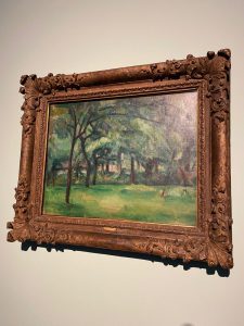 a green landscape painting by Paul Cézanne