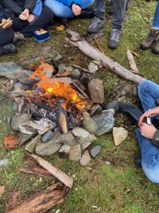 Students sitting around a small campfire