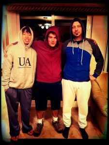 The author, in a maroon hoodie and navy blue shorts, posing for an early morning photo with his host brother, right, and flatmate, left.