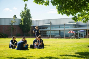 Group of students in scrubs sit outside at Linfield University Portland Campus